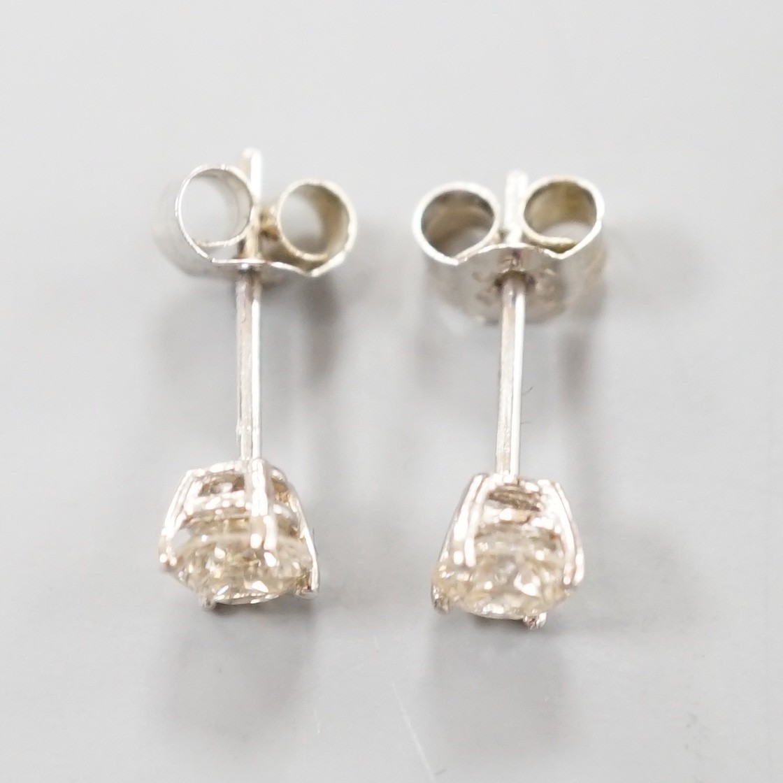 A pair of white metal and solitaire diamond set ear studs, gross weight 0.8 grams, stone diameter approx. 3.5mm.